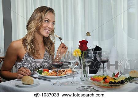 Stock Photo - Girl at the restaurant while dining. Fotosearch
