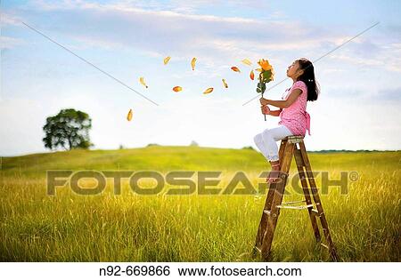 Girl blowing big flower petals. Illinois View Large Photo Image Stock Photograph - Girl blowing big flower petals. Illinois. Fotosearch