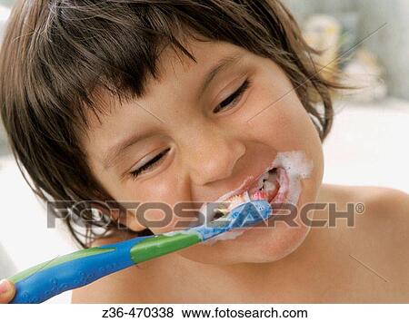 Stock Photo - Girl brushing teeth in bathroom. Fotosearch