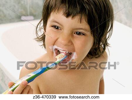 Stock Photo - Girl brushing teeth in bathroom. Fotosearch