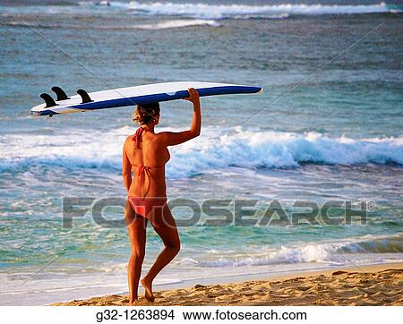 Girl carries surfboard on beach, Hawaii, USA View Large Photo Image Picture - Girl carries surfboard on beach, Hawaii, USA. Fotosearch