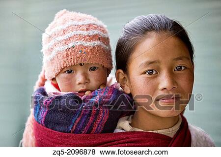 Girl carrying baby on back. Tawang, Arunachal Pradesh, India. View Large Photo Image Stock Photo - Girl carrying baby on back. Tawang, Arunachal Pradesh, India.. Fotosearch