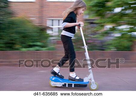 Stock Photography - Girl child riding electric scooter. Fotosearch