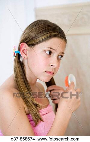 Girl combing herself in the bathroom View Large Photo Image Picture - Girl combing herself in the bathroom. Fotosearch