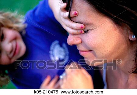 Girl covering her mother's eyes with her hand View Large Photo Image Stock Photography - Girl covering her mother's eyes with her hand. Fotosearch