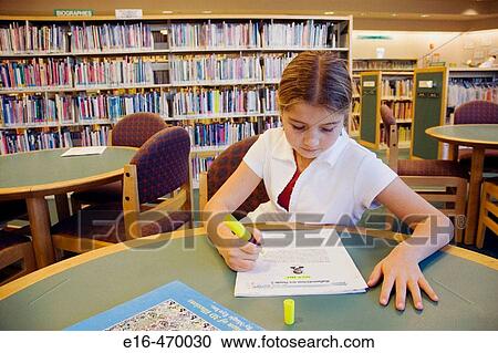 Stock Image - girl doing homework in the library. Fotosearch
