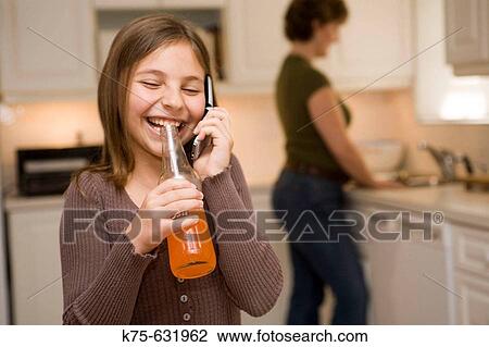 Girl drinking soft drink with mom in kitchen. View Large Photo Image Stock Image - Girl drinking soft drink with mom in kitchen.. Fotosearch