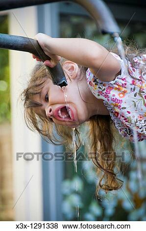 Stock Photo - Girl drinking water from a water fountain. Fotosearch