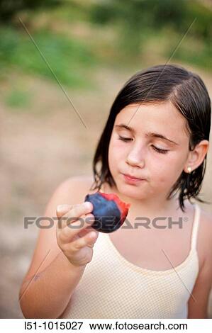 Girl eating a plum View Large Photo Image Stock Photo - Girl eating a plum. Fotosearch
