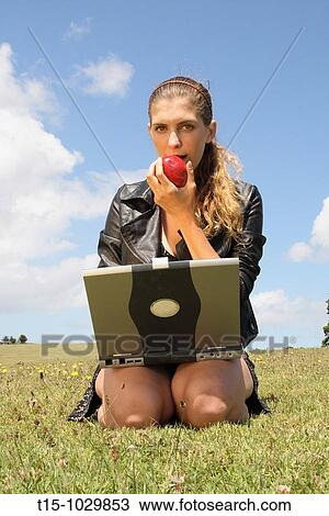 girl eating an apple using a laptop in a park View Large Photo Image Stock Image - girl eating an apple using a laptop in a park. Fotosearch