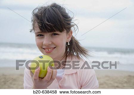 Girl eating apple on beach View Large Photo Image Stock Photo - Girl eating apple on beach. Fotosearch