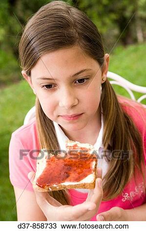 Girl eating bread with jam View Large Photo Image Stock Image - Girl eating bread with jam. Fotosearch