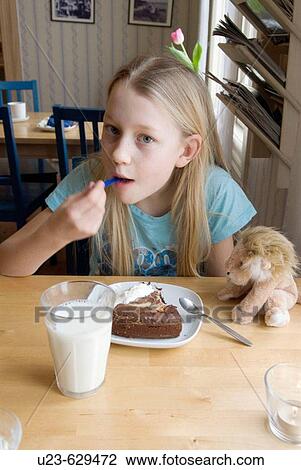 Stock Image - Girl eating cake.. Fotosearch