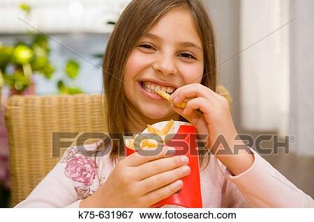 Girl eating french fries View Large Photo Image Stock Photo - Girl eating french fries. Fotosearch