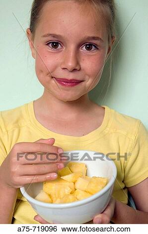 Stock Photograph - Girl eating fruit. Fotosearch