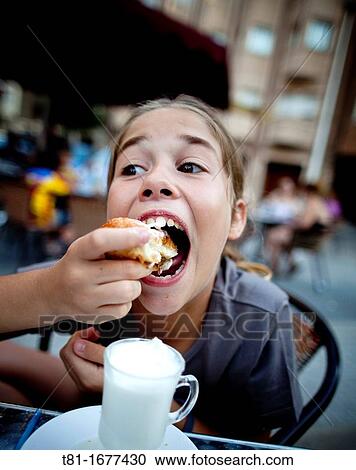 Girl eating in an outdoor caf? View Large Photo Image Stock Image - Girl eating in an outdoor caf?. Fotosearch