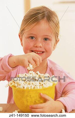 Stock Image - Girl eating popcorns. Fotosearch