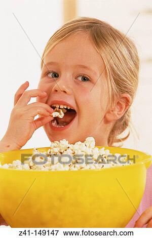 Girl eating popcorns View Large Photo Image Stock Photo - Girl eating popcorns. Fotosearch