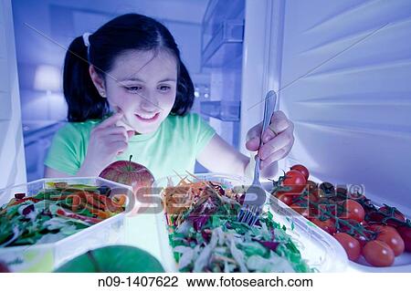 Girl eating salad in the fridge View Large Photo Image Stock Image - Girl eating salad in the fridge. Fotosearch