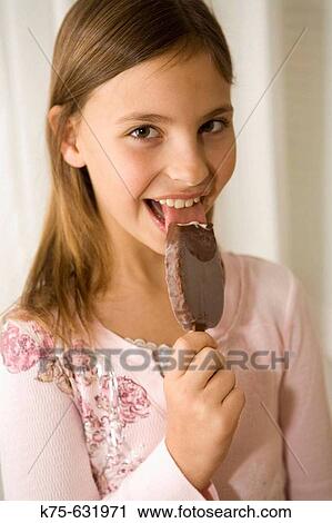 Stock Image - Girl enjoying ice cream on a stick. Fotosearch
