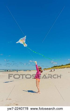 Girl flying a kite on a beach in Bialogora, Poland. View Large Photo Image Stock Photo - Girl flying a kite on a beach in Bialogora, Poland.. Fotosearch
