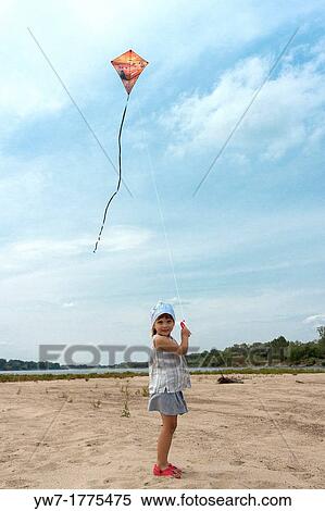 Girl flying kite on Vistula river beach, Poland View Large Photo Image Stock Photography - Girl flying kite on Vistula river beach, Poland. Fotosearch