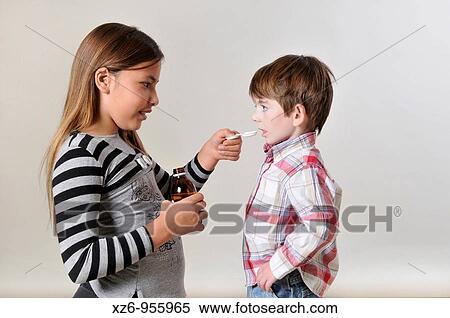 Girl giving medicine to young children View Large Photo Image Stock Photography - Girl giving medicine to young children. Fotosearch