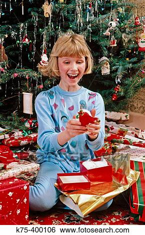 Girl happy with Christmas present View Large Photo Image Stock Photograph - Girl happy with Christmas present. Fotosearch