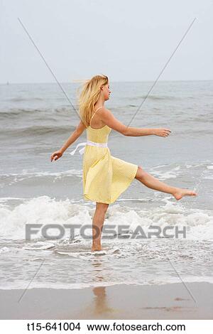 Girl having fun walking and splashing water on the beach View Large Photo Image Picture - Girl having fun walking and splashing water on the beach. Fotosearch