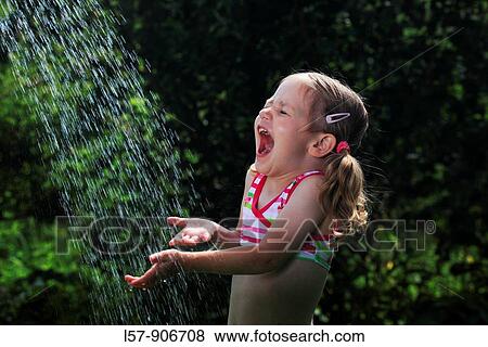 Stock Photo - girl having shower outdoors, Switzerland. Fotosearch