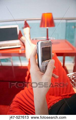 Girl holding a mobile phone, red shoes, skirt, table and light View Large Photo Image Stock Image - Girl holding a mobile phone, red shoes, skirt, table and light. Fotosearch