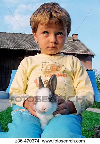Girl holding rabbit View Large Photo Image Picture - Girl holding rabbit. Fotosearch