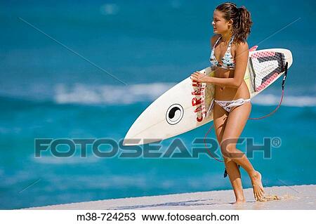 Stock Image - Girl holding surf board, Oahu, Hawaii, USA. Fotosearch