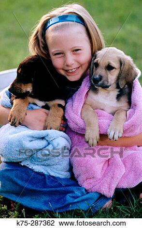 Stock Image - Girl hugging her puppies. Fotosearch