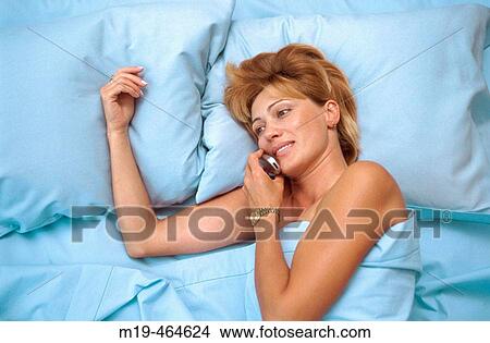 girl in bed on a cell View Large Photo Image Picture - girl in bed on a cell. Fotosearch