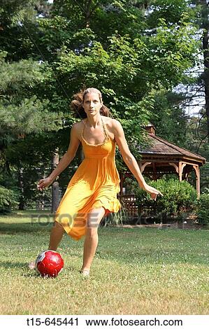 Girl in her 20's in a summer dress having fun playing soccer barefooted in a park. View Large Photo Image Stock Image - Girl in her 20's in a summer dress having fun playing soccer barefooted in a park.. Fotosearch
