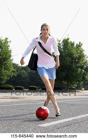 Girl in her 20's in work clothes carrying a laptop playing soccer in parking lot on her way to work. View Large Photo Image Stock Image - Girl in her 20's in work clothes carrying a laptop playing soccer in parking lot on her way to work.. Fotosearch