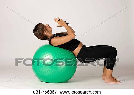 Girl in her early 40s exercising with a ball View Large Photo Image Stock Photo - Girl in her early 40s exercising with a ball. Fotosearch