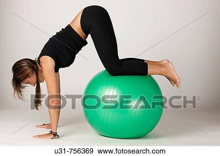 Girl in her early 40s exercising with a ball View Large Photo Image Stock Photo - Girl in her early 40s exercising with a ball. Fotosearch