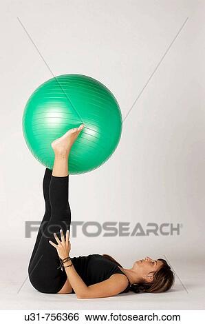 Girl in her early 40s exercising with a ball View Large Photo Image Stock Photograph - Girl in her early 40s exercising with a ball. Fotosearch