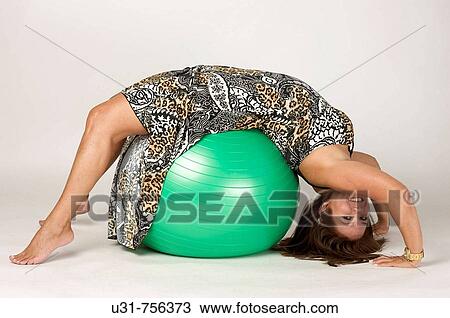 Girl in her early 40s playing with an exercise ball View Large Photo Image Stock Image - Girl in her early 40s playing with an exercise ball. Fotosearch