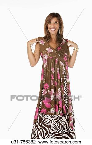Stock Image - Girl in her early 40s trying on a new dress. Fotosearch