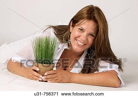 Girl in her early 40s with a plant on her hand View Large Photo Image Stock Image - Girl in her early 40s with a plant on her hand. Fotosearch