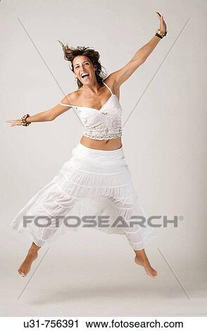 Girl in her early 40s with wind in her hair smiling jumping View Large Photo Image Stock Image - Girl in her early 40s with wind in her hair smiling jumping. Fotosearch