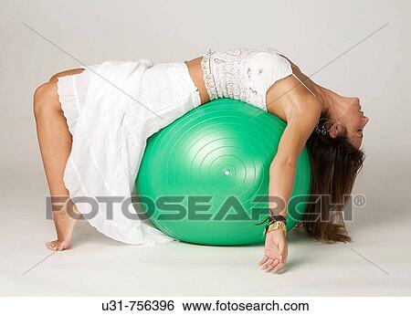 Girl in her late 30s resting on an exercise ball View Large Photo Image Stock Photograph - Girl in her late 30s resting on an exercise ball. Fotosearch