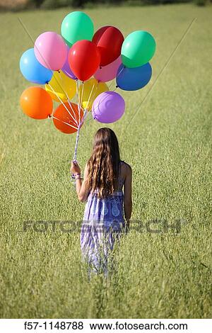 Girl in meadow with balloons View Large Photo Image Stock Photo - Girl in meadow with balloons. Fotosearch