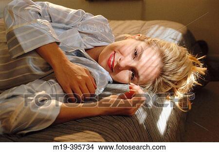 girl in pajamas lying on a sunlight bed View Large Photo Image Picture - girl in pajamas lying on a sunlight bed. Fotosearch