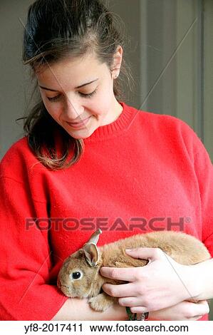 Stock Image - Girl in red with her rabbit.. Fotosearch