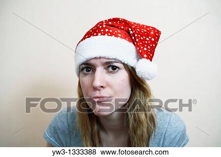 Stock Photo - girl in Santa hat looking at camera. Fotosearch