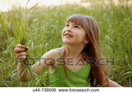 Girl in the grass looking up View Large Photo Image Stock Photograph - Girl in the grass looking up. Fotosearch